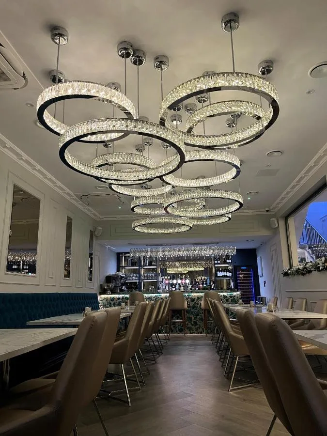 a dining room with tables and chairs and chandeliers at Philharmonic Hotel in Liverpool