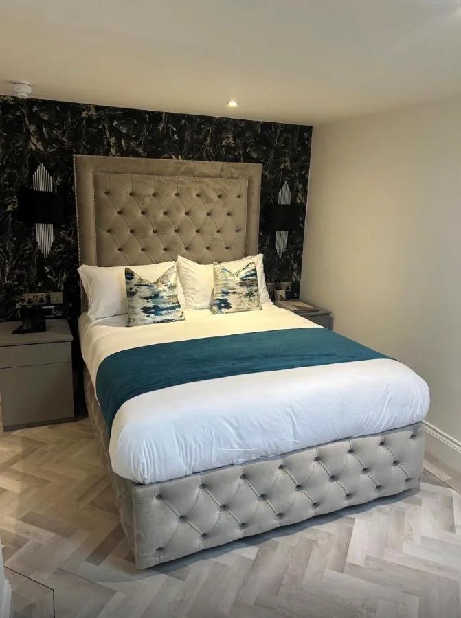 a bedroom with a large bed with a large headboard at Philharmonic Hotel in Liverpool